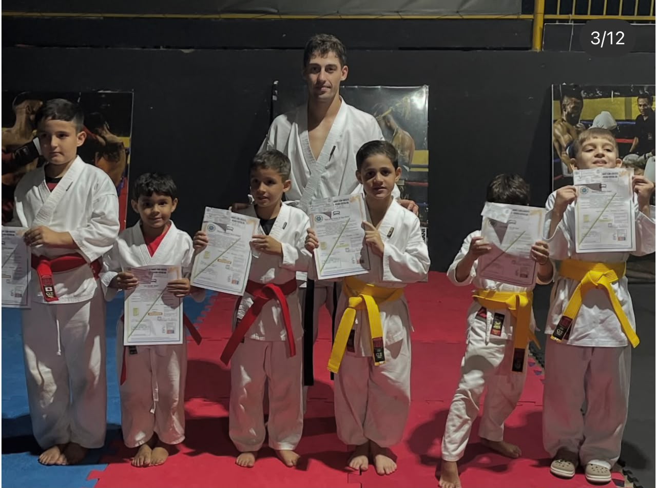 Crianças da turma de Karatê recebendo certificados de graduação